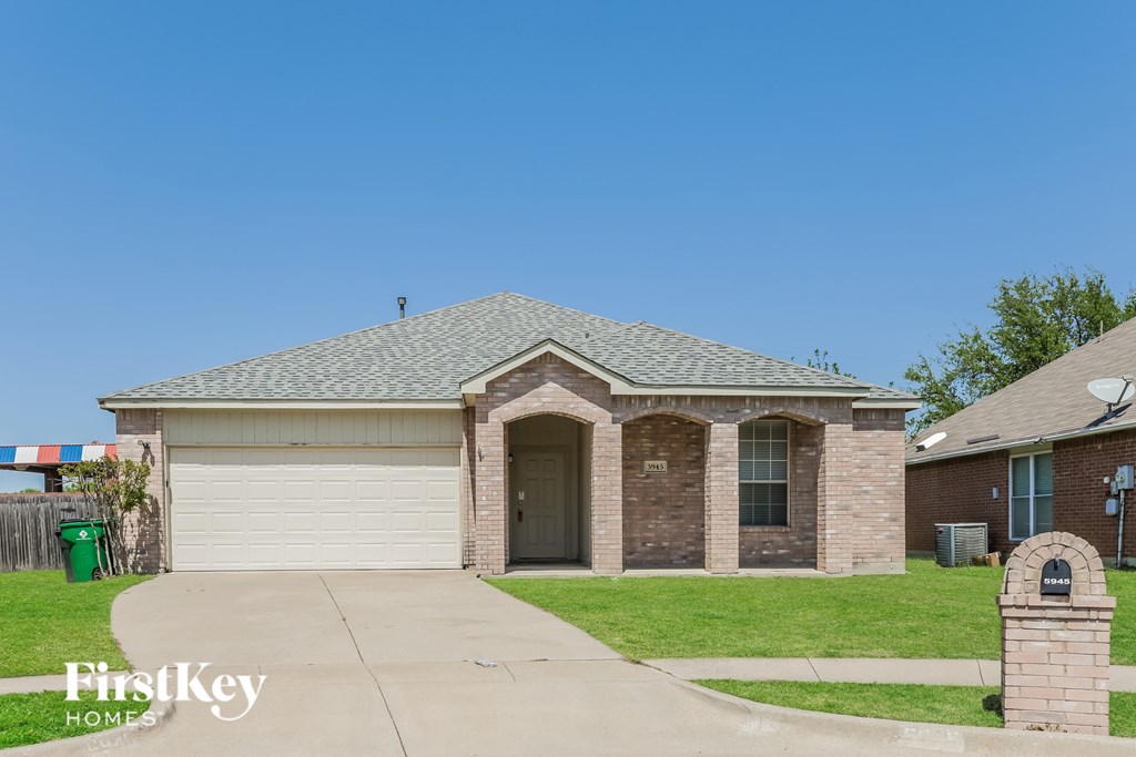 A house with a garage and a driveway in front of it.