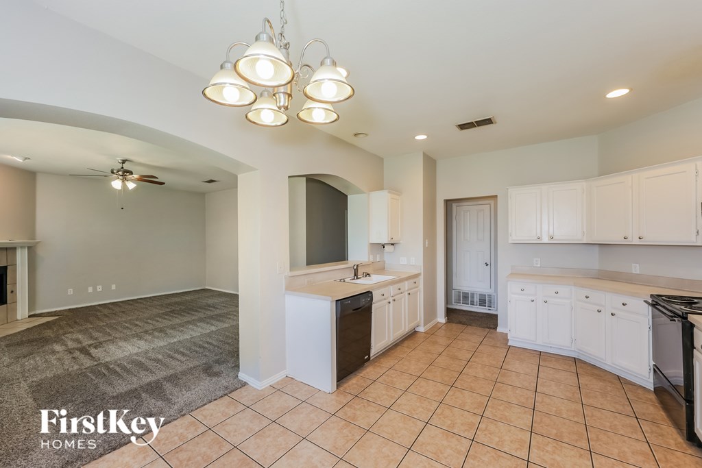 A kitchen with a tile floor and a ceiling fan.