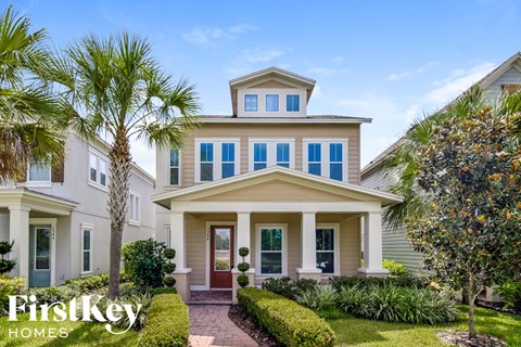 A house with a front yard and palm trees.