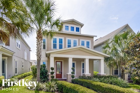 A house with a red door and a palm tree in front.