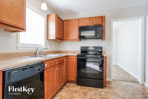 A kitchen with wooden cabinets and black appliances.