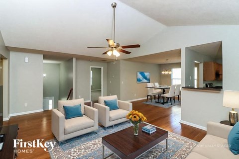 A living room with a white couch and a brown coffee table.