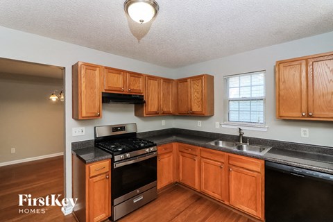 A kitchen with wooden cabinets and a black countertop.