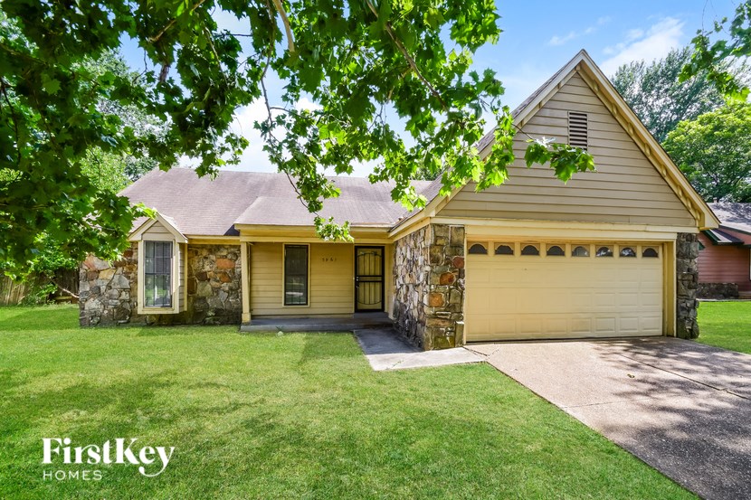 A house with a stone pillar and a garage door.