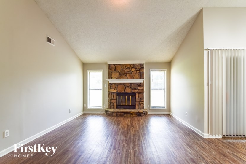 A room with a fireplace and wooden floors.