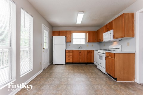 A kitchen with wooden cabinets and white appliances.