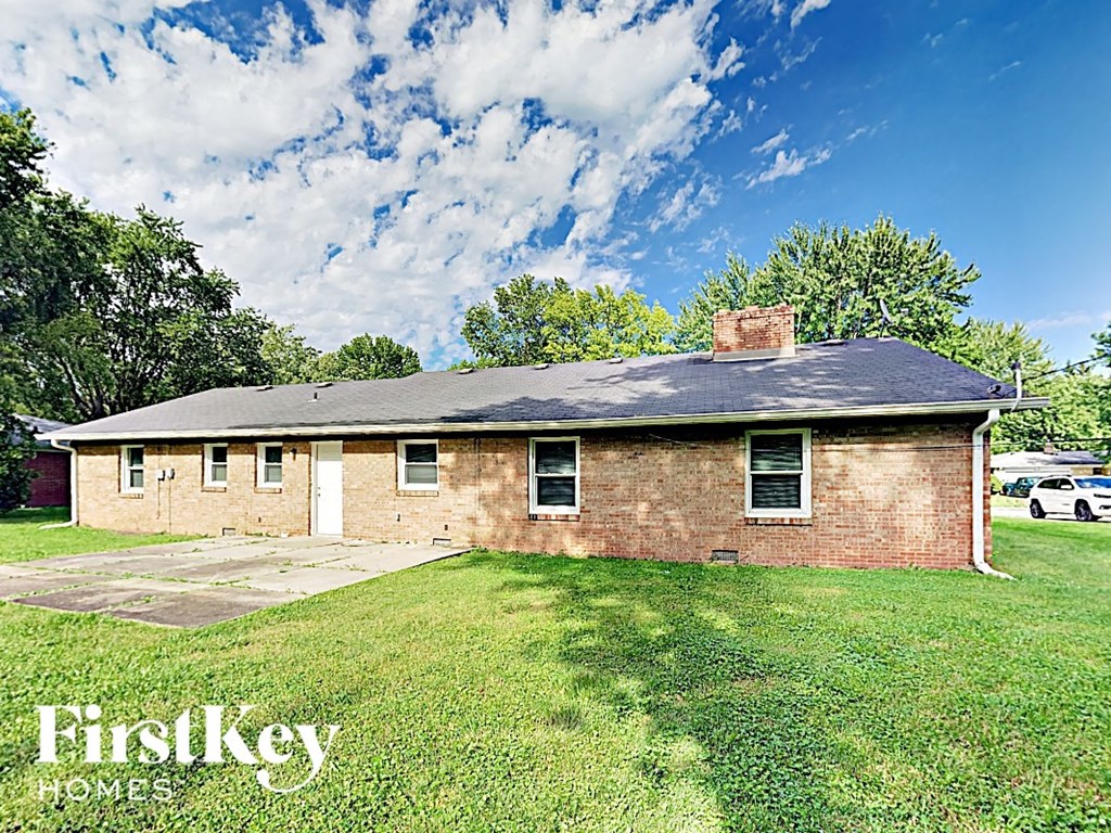 A brick house with a white door and windows is for sale.