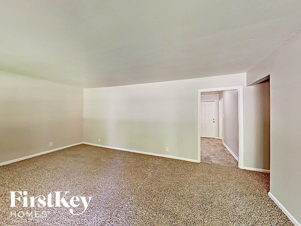 A room with a carpeted floor and a doorway leading to another room.