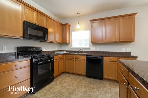 A kitchen with wooden cabinets and black appliances.