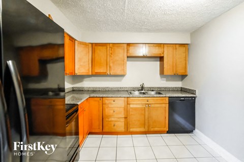 a kitchen with wooden cabinets and a sink and a refrigerator