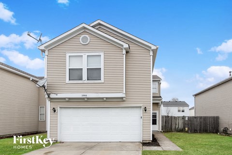 A house with a garage and a driveway in front of it.