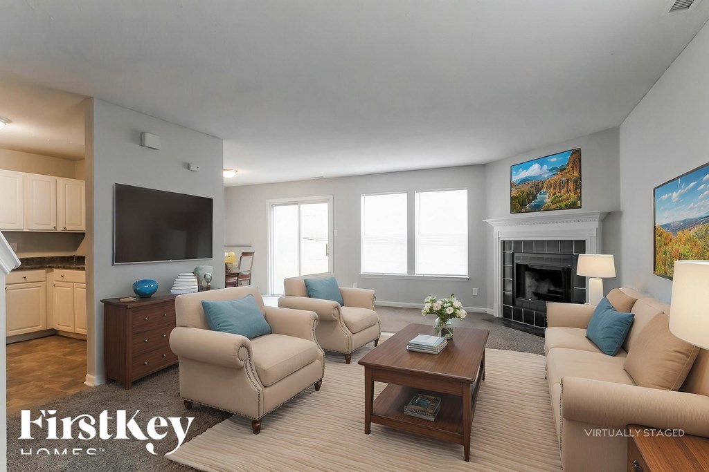 A living room with a fireplace and a painting on the wall.