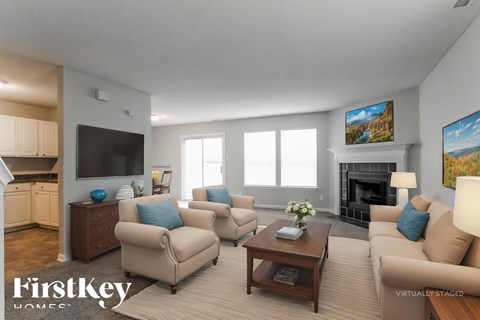 A living room with a fireplace and a painting on the wall.