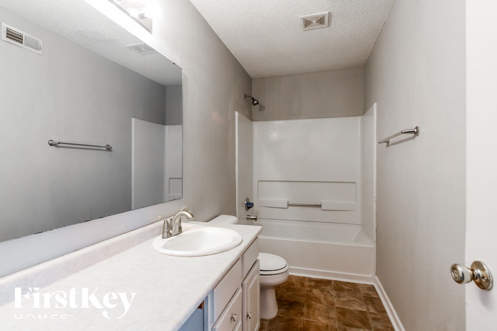 A white bathroom with a sink, toilet and bathtub.