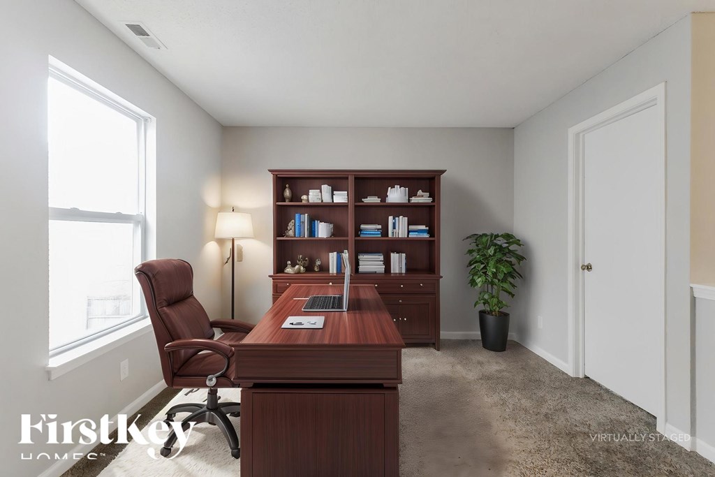 A room with a desk, chair, and bookshelf.
