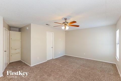 a bedroom with carpet and a ceiling fan