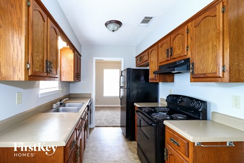 A kitchen with wooden cabinets and black appliances.