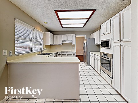 A kitchen with white cabinets and a white island.
