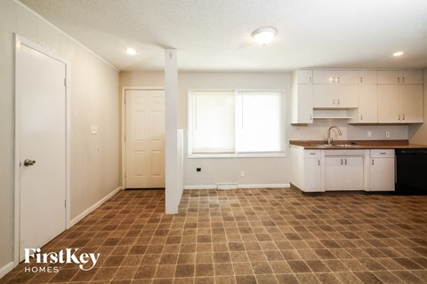 a kitchen with white cabinets and a sink and a window