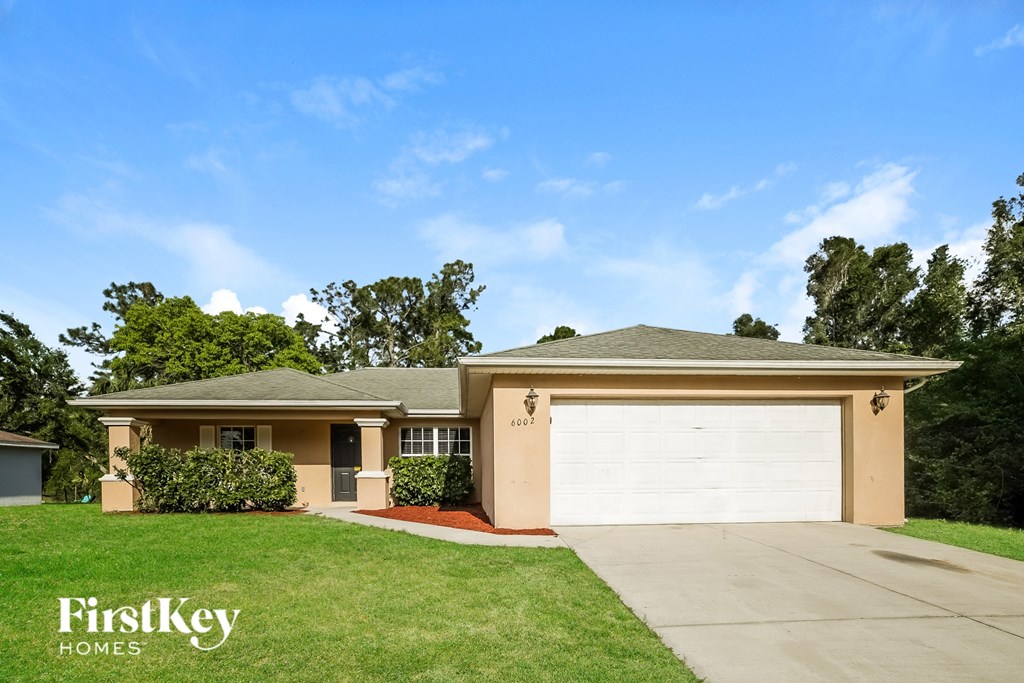 A house with a garage door and a sign that says FirstKey Homes.