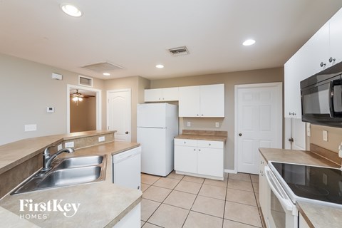 A kitchen with white cabinets and a sink.