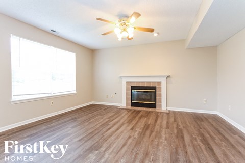 a living room with a fireplace and a ceiling fan