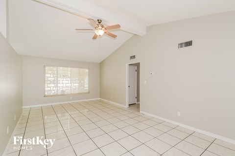 A spacious room with a ceiling fan and tiled floor.