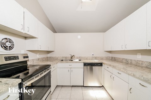 A kitchen with white cabinets and a stainless steel dishwasher.
