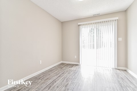 a spacious living room with wood floors and a sliding glass door