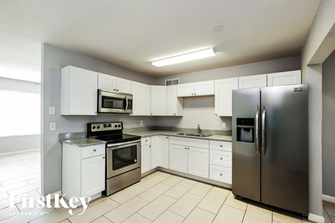 A kitchen with stainless steel appliances and white cabinets.