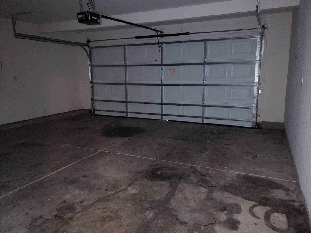 a garage with white doors and a cement floor