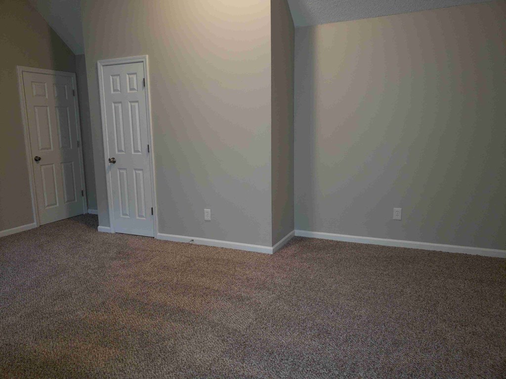 a room with a carpeted floor and a door