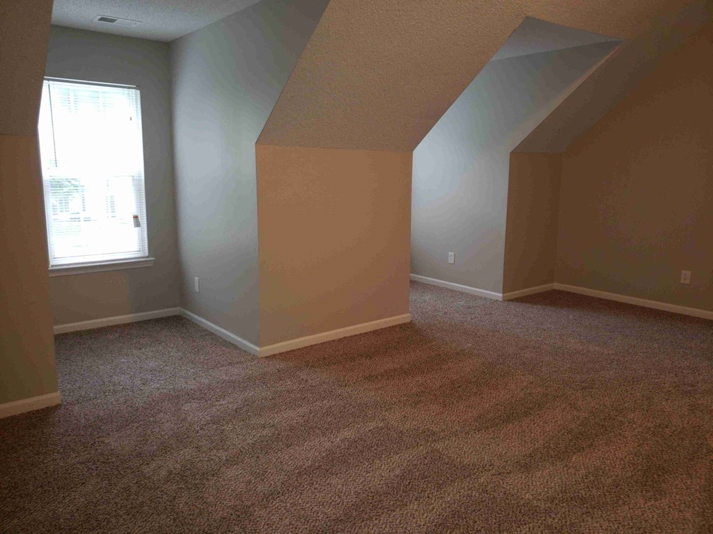 an empty room with carpet and a window