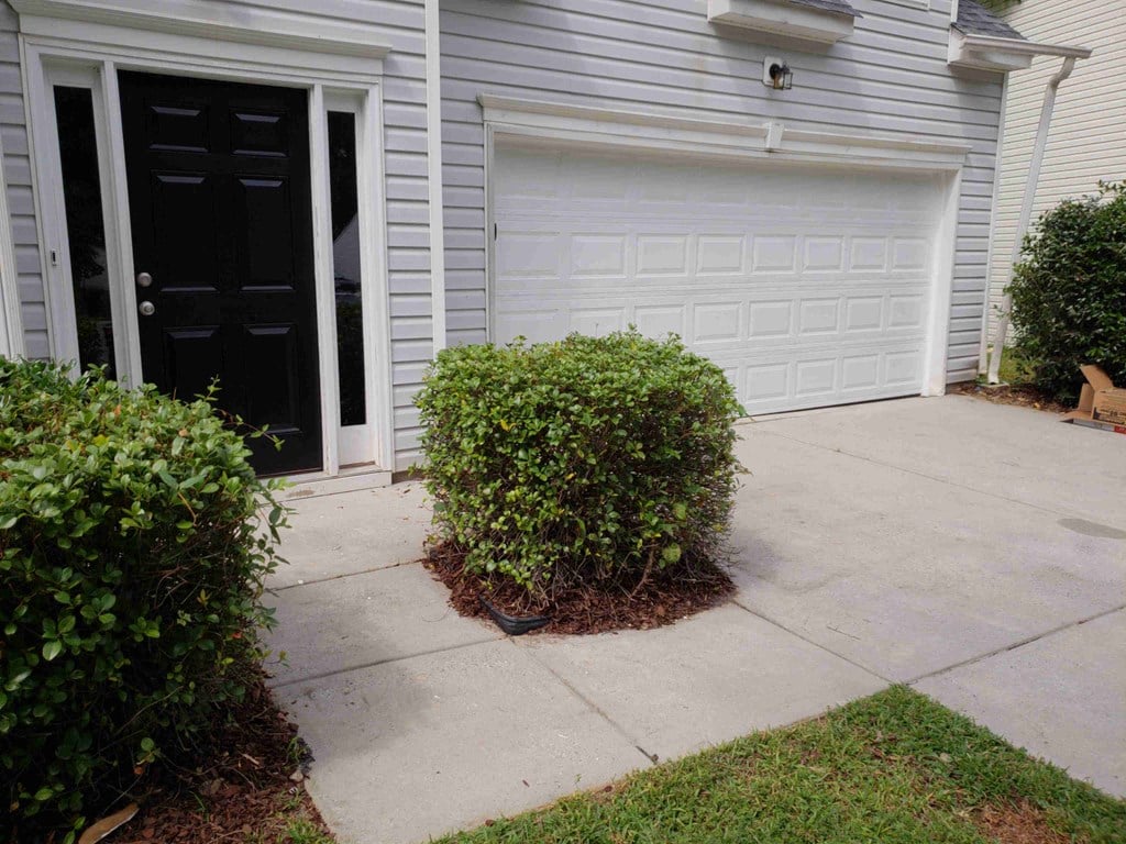 a driveway in front of a house with two garage doors