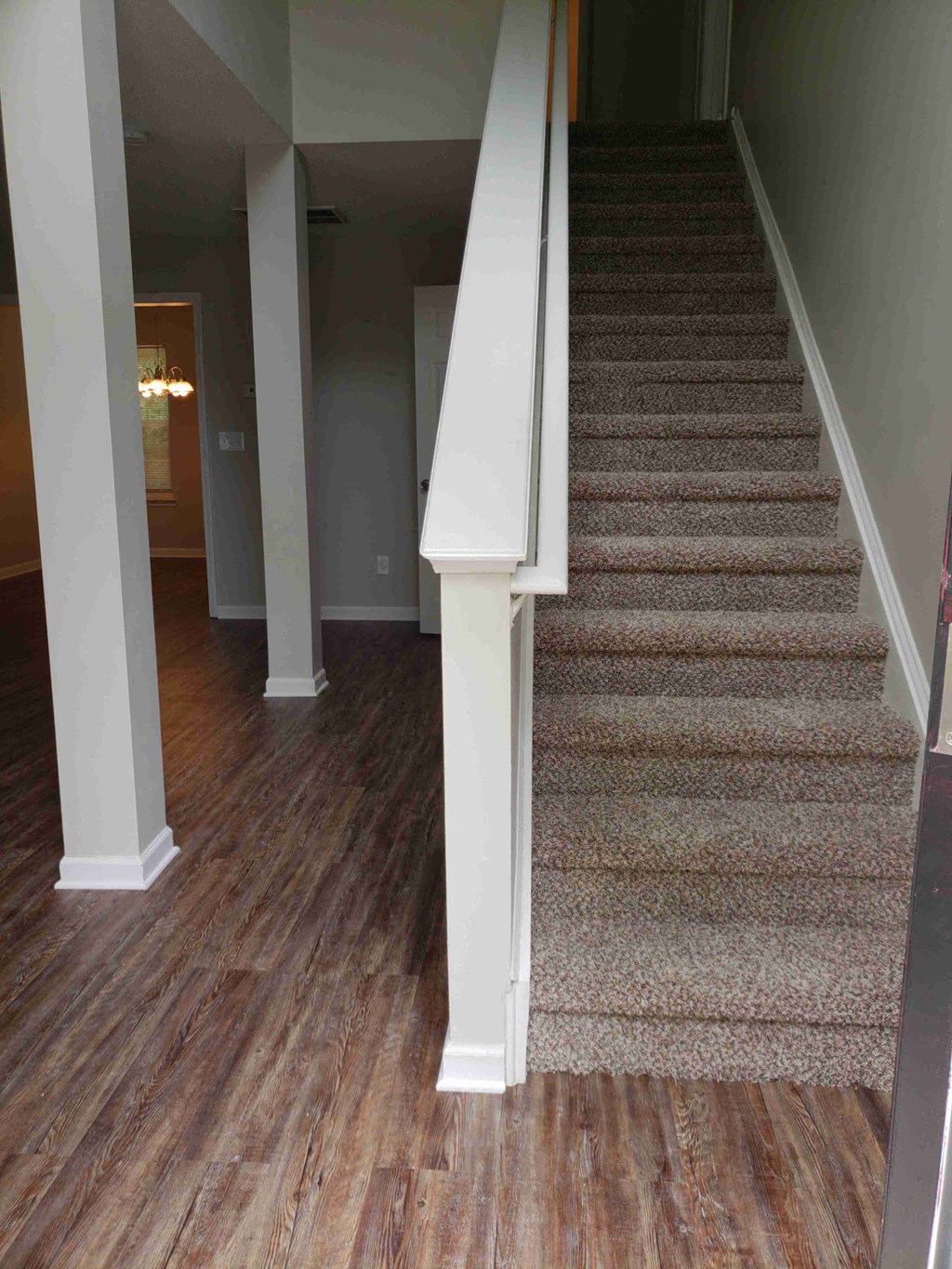a carpeted staircase in a home with a hard wood floor