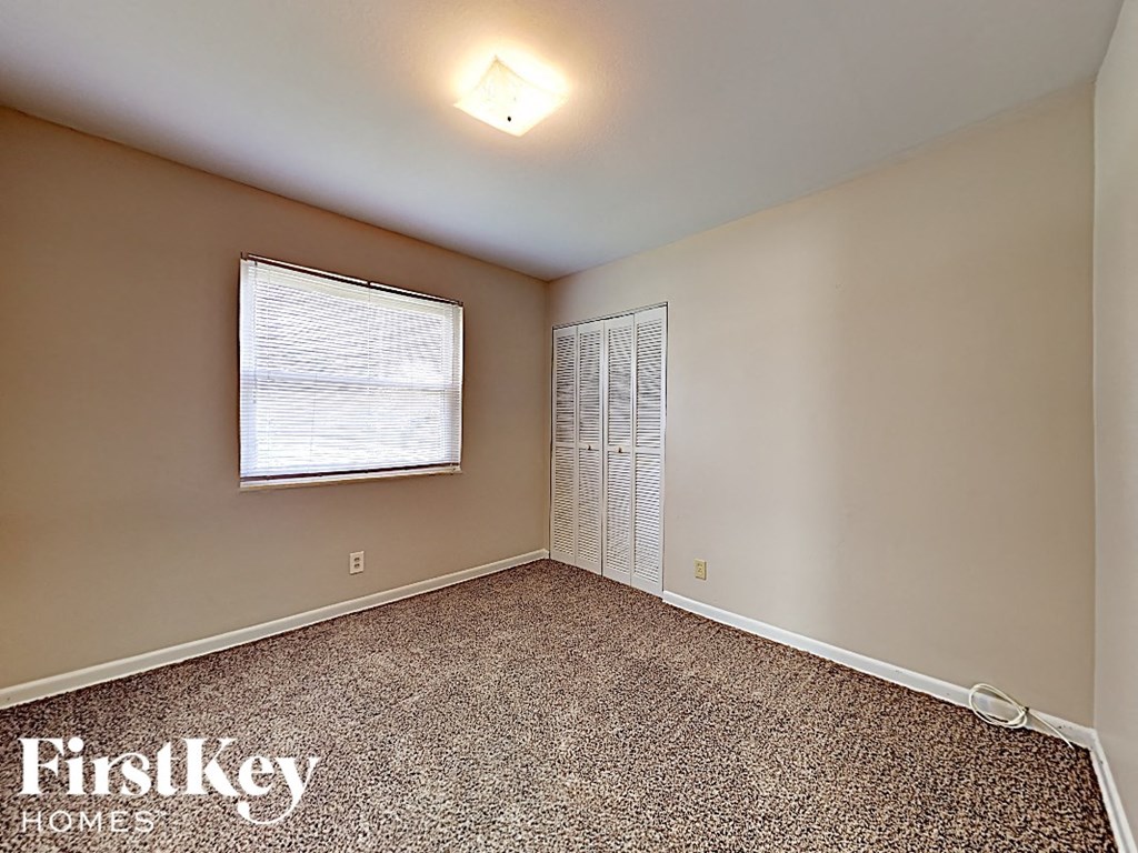 an empty room with a window and a closet