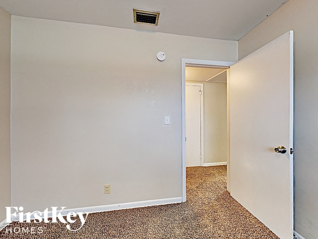 an empty bedroom with white walls and a white door