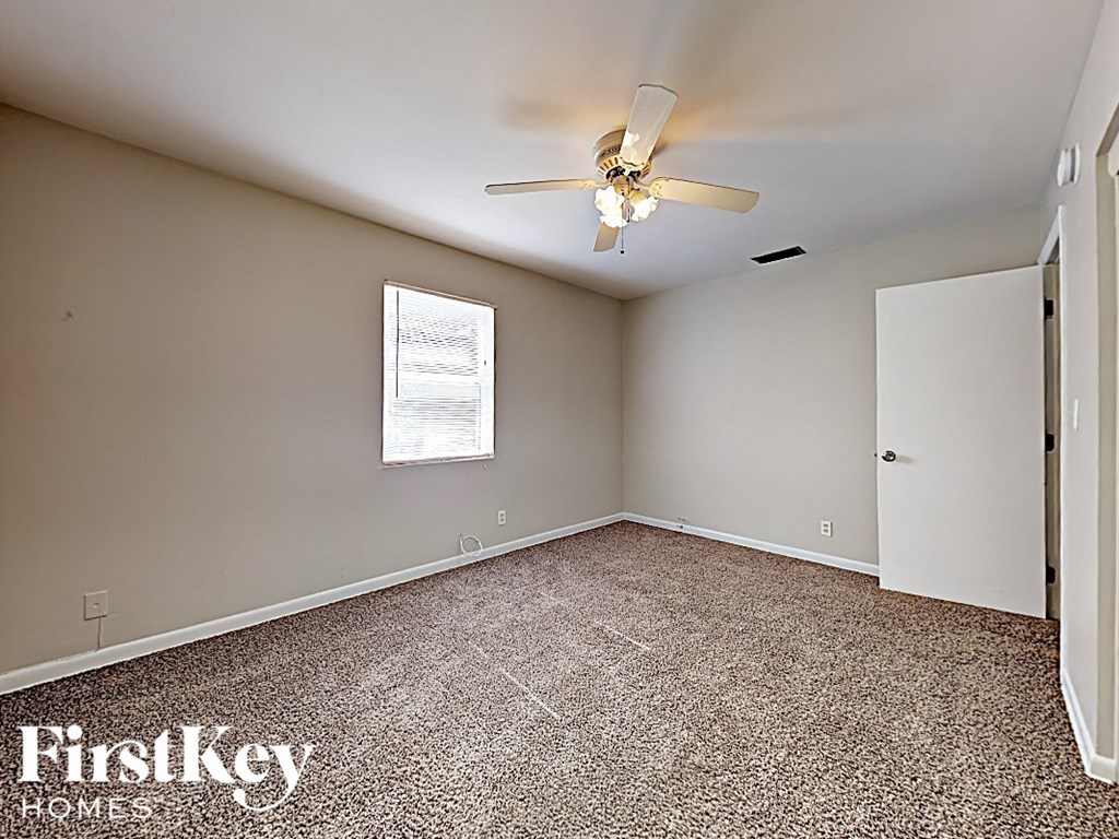 an empty room with a ceiling fan and a white door