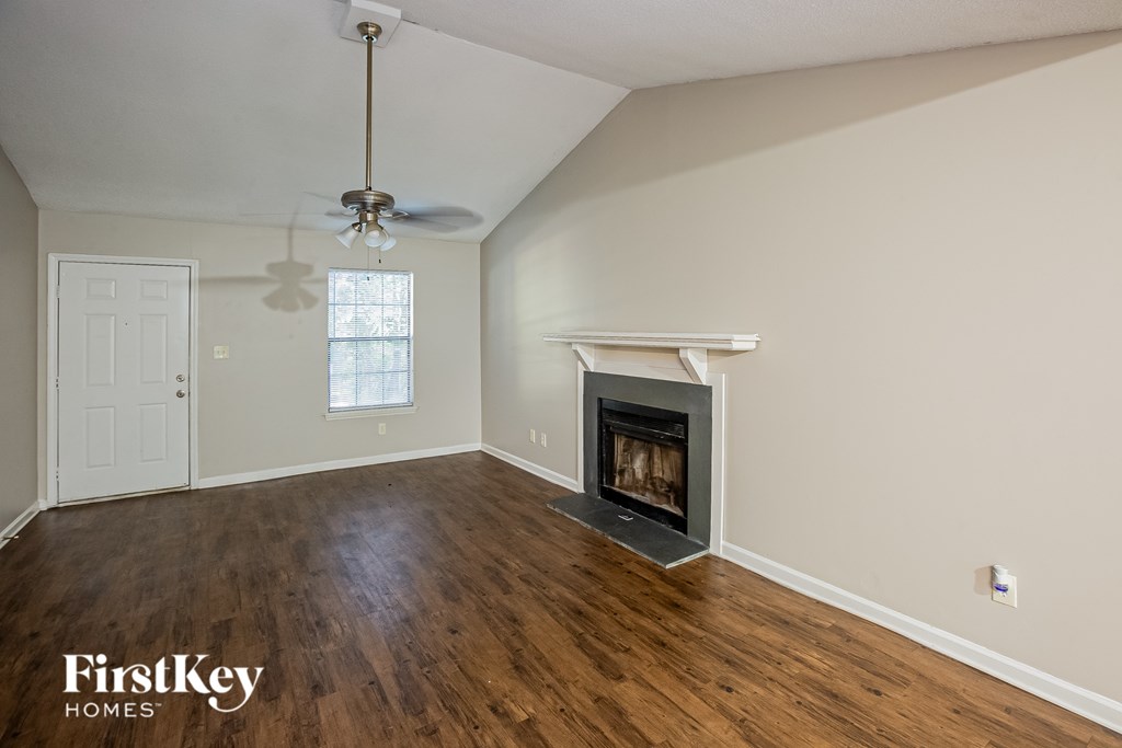 A room with a fireplace and a ceiling fan.