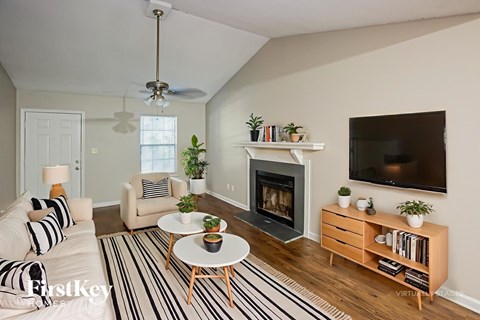 A living room with a fireplace and a television on the wall.