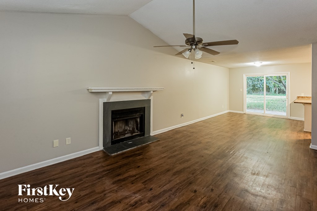 A room with a fireplace and a ceiling fan.