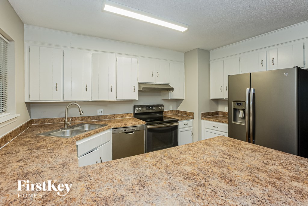A kitchen with granite countertops and stainless steel appliances.