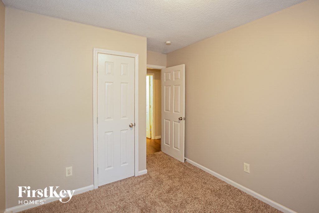 A room with two doors and a carpeted floor.