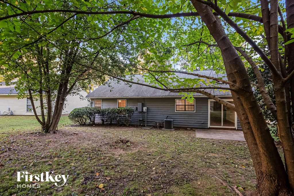 A tree in front of a house with a sign that says "FirstKey Homes".