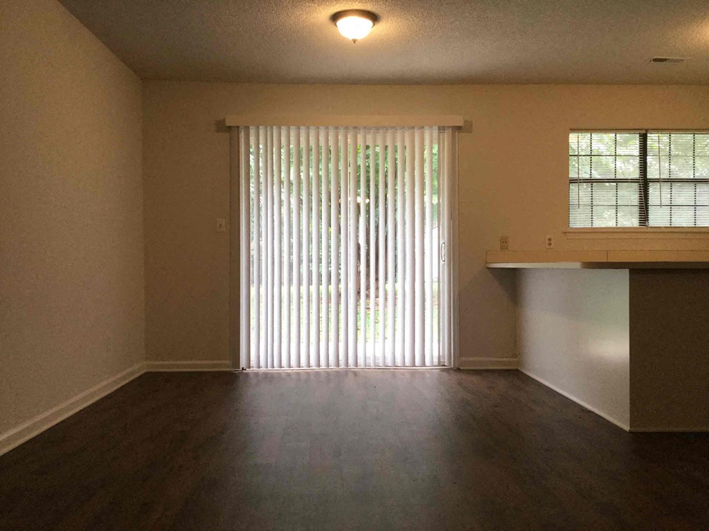 an empty living room with wood floors and a window