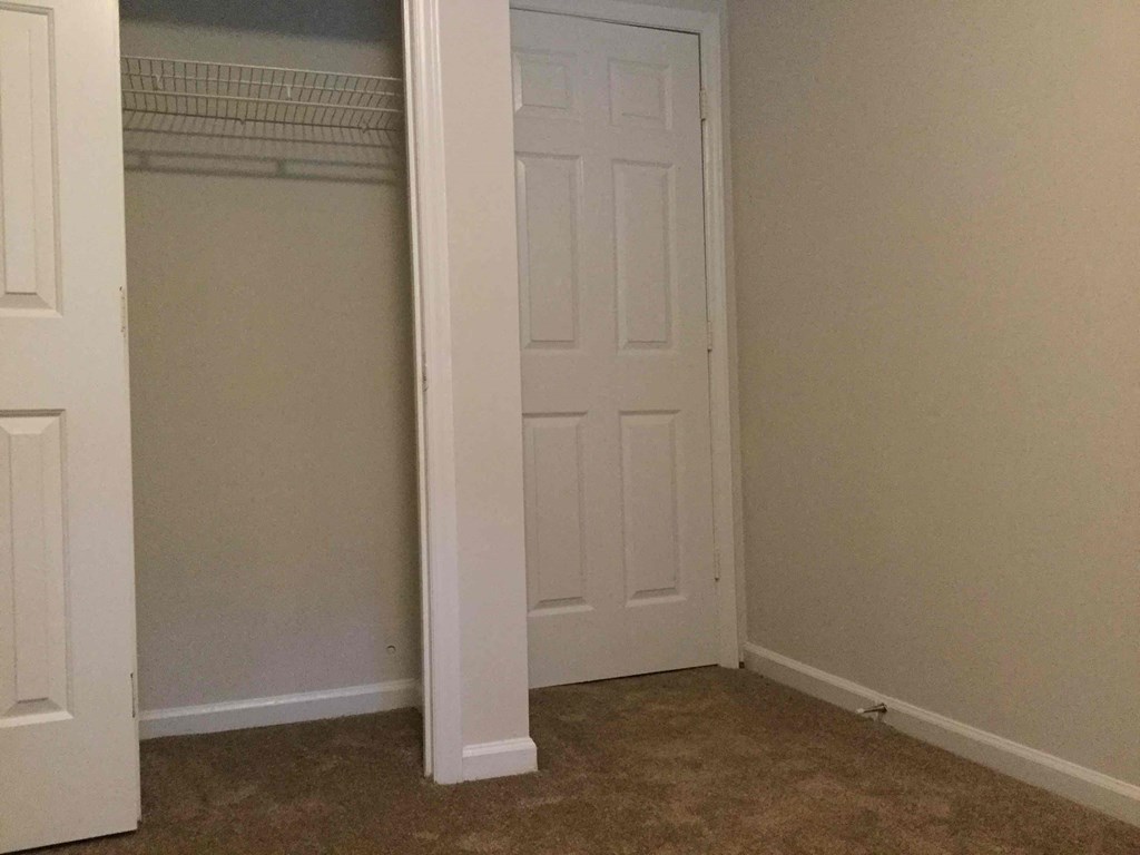 a room with a closet and a white door