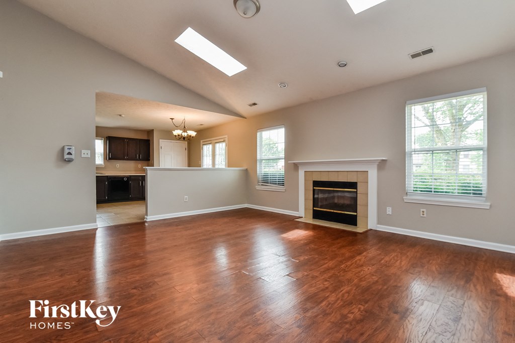 an empty living room with wood flooring and a fireplace