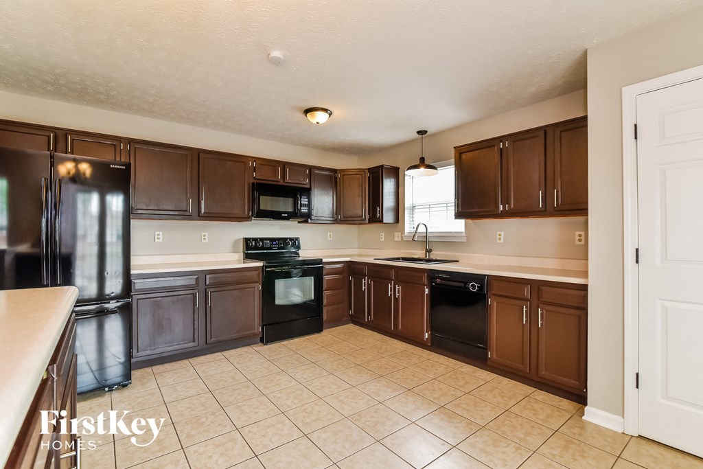 a kitchen with wooden cabinets and black appliances