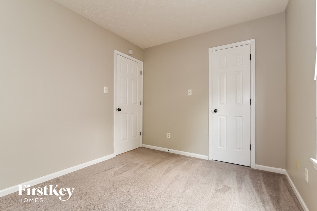 a bedroom with two doors and a carpeted floor
