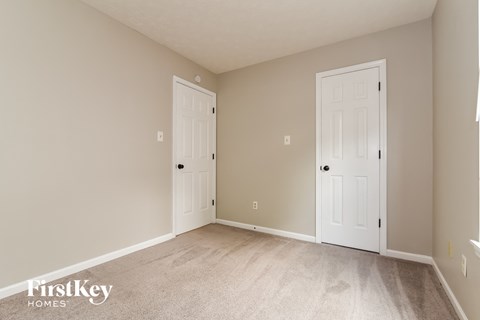 a bedroom with two doors and a carpeted floor